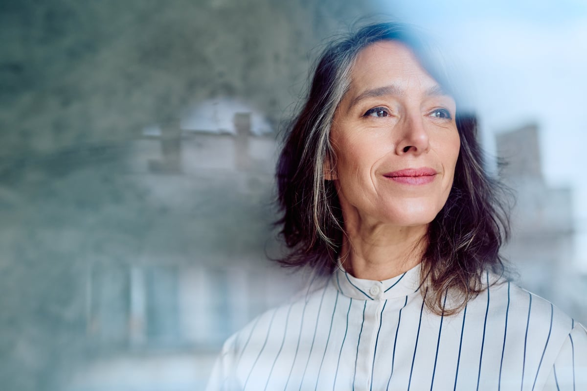 Confident woman smiling while reflecting on her plans and envisioning success